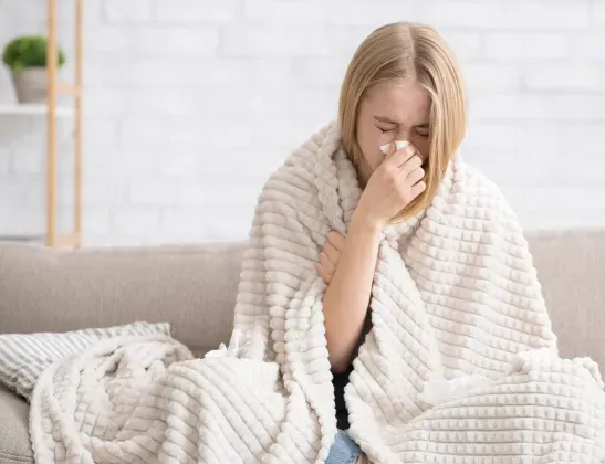 woman wrapped in blanket sick